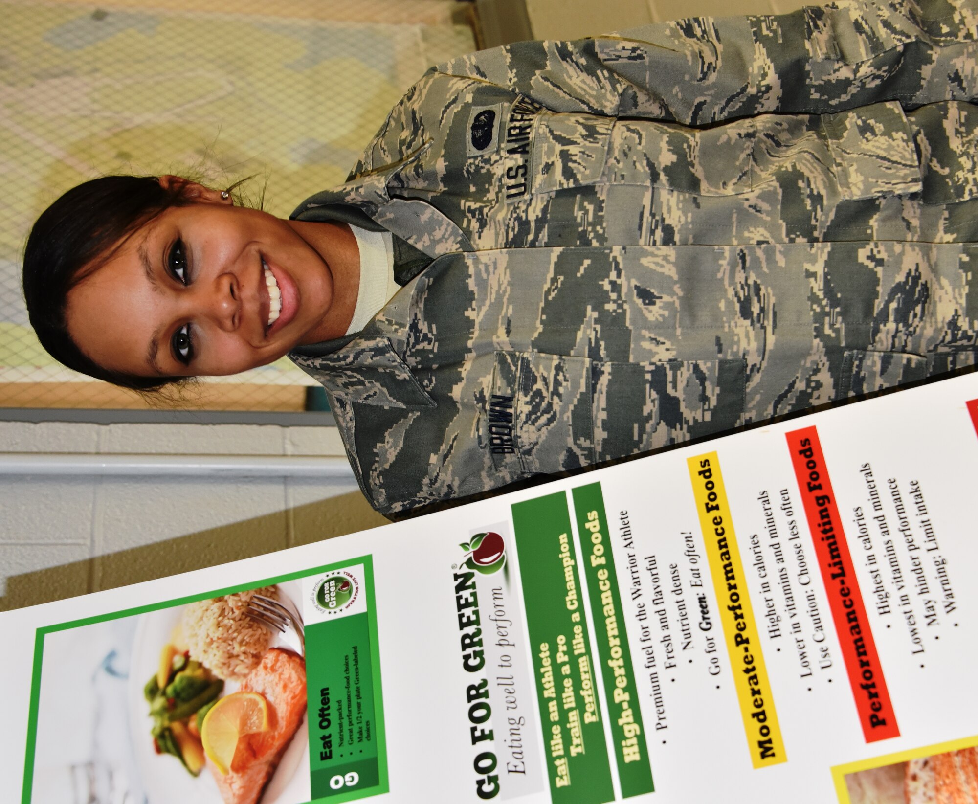 Airman 1st Class Robin Brown is the 175th Wing's March Airman Spotlight. She is a member of the 175th Force Support Squadron and is pictured with the Go For Green eating well program poster in the base dining facility. (U.S. Air National Guard photo by Senior Master Sgt. Ed Bard/RELEASED)