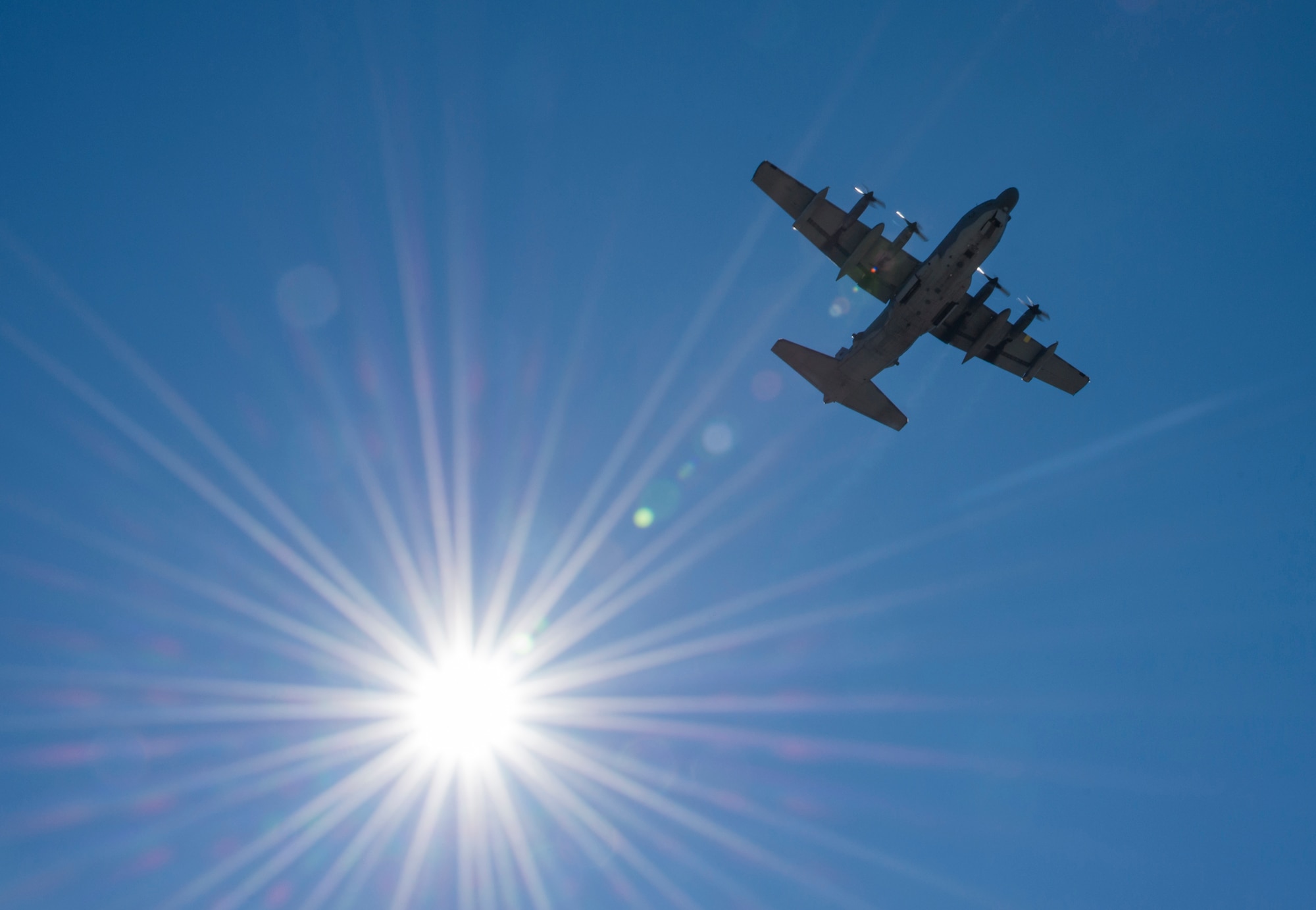 A C-130 soars by the sun while doing some pattern work over Duke Field’s flightline Jan. 28.  (U.S. Air Force photo/Tech. Sgt. Jasmin Taylor)