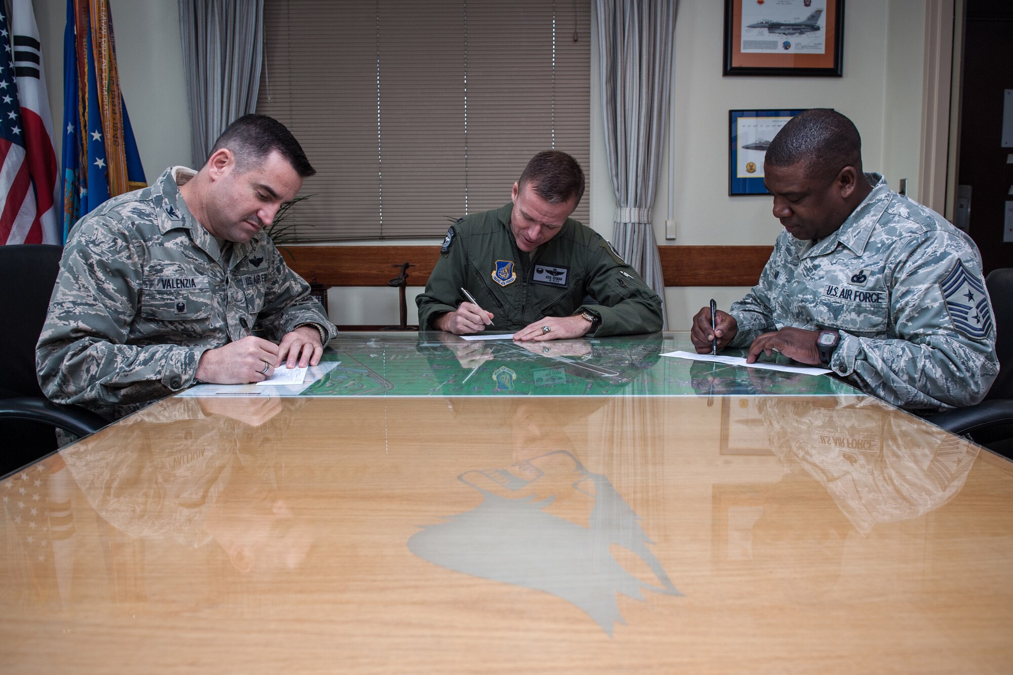 (Left to right) Col. Jeffery “Wolf II” Valenzia, 8th Fighter Wing vice commander, Col. Ken “Wolf” Ekman, 8th FW commander, and Chief Master Sgt. Lee “Wolf Chief” Barr, 8th FW command chief, fill out their Air Force Assistance Fund forms at Kunsan Air Base, Republic of Korea, Mar. 2, 2015. The AFAF campaign, which helps Airmen and families in their times of greatest need, officially kicked off today at Kunsan and concludes on April 10. (U.S. Air Force photo by Senior Airman Taylor Curry/Released) 