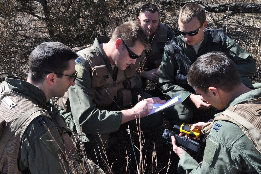 McConnell Reservists take a minute to access their location during a Survival, Evasion, Resistance, Escape training scenario in a wooded area in Derby, Kan., March 7, 2015.  Fifteen McConnell Reservists participated in the training during the March unit training assembly. (U.S. Air Force photo by Tech. Sgt. Abigail Klein)
