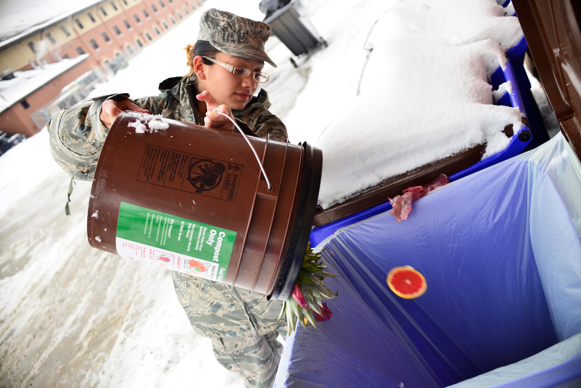 Senior Airman Grissel Reyes, 914th Force Support Squadron, disposes of compostable material at the Niagara Falls Air Reserve Station, Feb. 7, 2015. The base was participating in a recent recycling initiative. (U.S. Air Force photo by Tech. Sgt. Stephanie Sawyer)