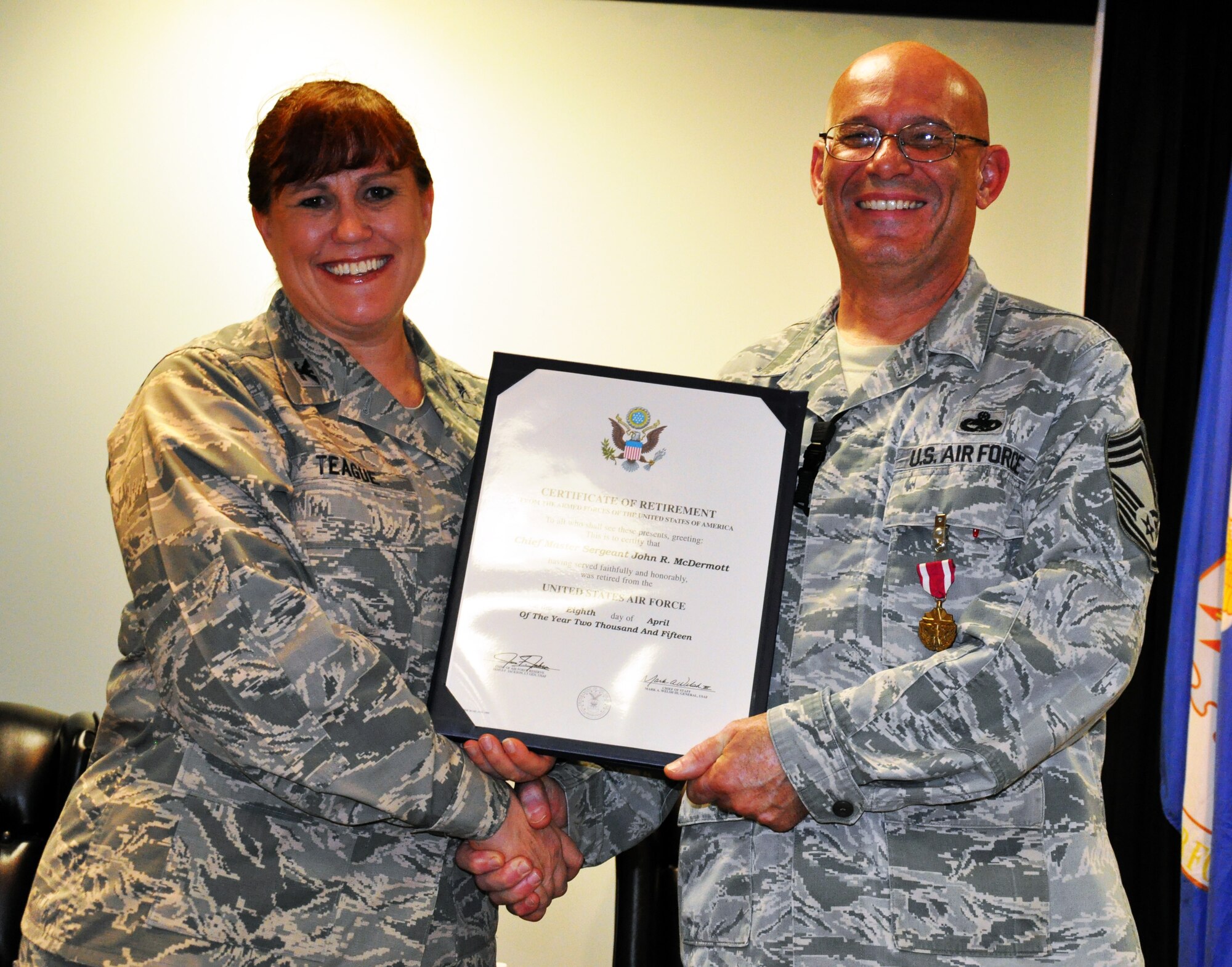 Col. Sherry Teague, Individual Mobilization Augmentee to the commander, 76th Aircraft Maintenance Group, Tinker Air Force Base, Okla., presents a certificate of retirement to Chief Master Sgt. John McDermott, 931st Aircraft Maintenance Squadron Superintendent, during McDermott's official retirement ceremony at McConnell Air Force Base, Kan., March 8, 2015.  The Chief enlisted in the Air Force in 1977 and started his career as a crew chief with the 474th Tactical Fighter Wing at Nellis Air Force Base, Nev.  He retired as the 931st Aircraft Maintenance Squadron Superintendent here at McConnell, where he led over 1,000 regular Air Force, Air Force Reserve, Civil Service and contract personnel from 6 Air Force Specialty Codes in support of 63 KC-135 aircraft.  (U.S. Air Force photo by Capt. Zach Anderson)
