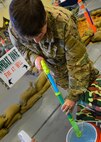 Maj. James Reed, 919th Special Operations Wing staff, refills his water gun at the Combat Dining-In Feb. 7 at Duke Field, Fla.  The event, the first in nine years, drew more than 250 Airmen.  A Combat Dining-In is built around the format of a traditional Dining-In, but there is less formality and combat uniforms are required. (U.S. Air Force photo/Tech. Sgt. Cheryl L. Foster)