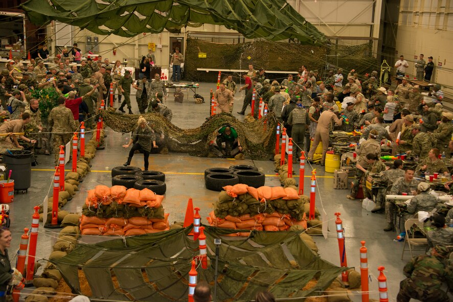 Members of the 919th Special Operations Wing spray water at those selected to run through the obstacle course at the Combat Dining-In Feb. 7 at Duke Field, Fla.  The event, the first in nine years, drew more than 250 Airmen.  A Combat Dining-In is built around the format of a traditional Dining-In, but there is less formality and combat uniforms are required. (U.S. Air Force photo/Tech. Sgt. Jasmin Taylor)