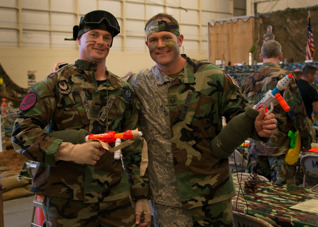 Tech. Sgt. Jeremy Mers (left), and Master Sgt. Christian Becker (right), 919th Special Operations Support Squadron, show off their weapons at the Combat Dining-In Feb. 7 at Duke Field, Fla.  The event, the first in nine years, drew more than 250 Airmen.  A Combat Dining-In is built around the format of a traditional Dining-In, but there is less formality and combat uniforms are required. (U.S. Air Force photo/Tech. Sgt. Jasmin Taylor)