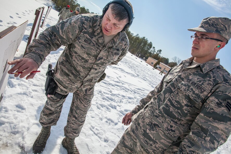 Staff Sgt. Lawrence J. Aiello left, Combat Arms Training and Maintenance, discusses target groupings with Senior Airman Nicholas J. Gordienko, both with 108th Wing, New Jersey Air National Guard, during M4 Carbine qualification at Joint Base McGuire-Dix-Lakehurst, N.J., March 8, 2015. (U.S. Air National Guard photo by Master Sgt. Mark C. Olsen/Released)