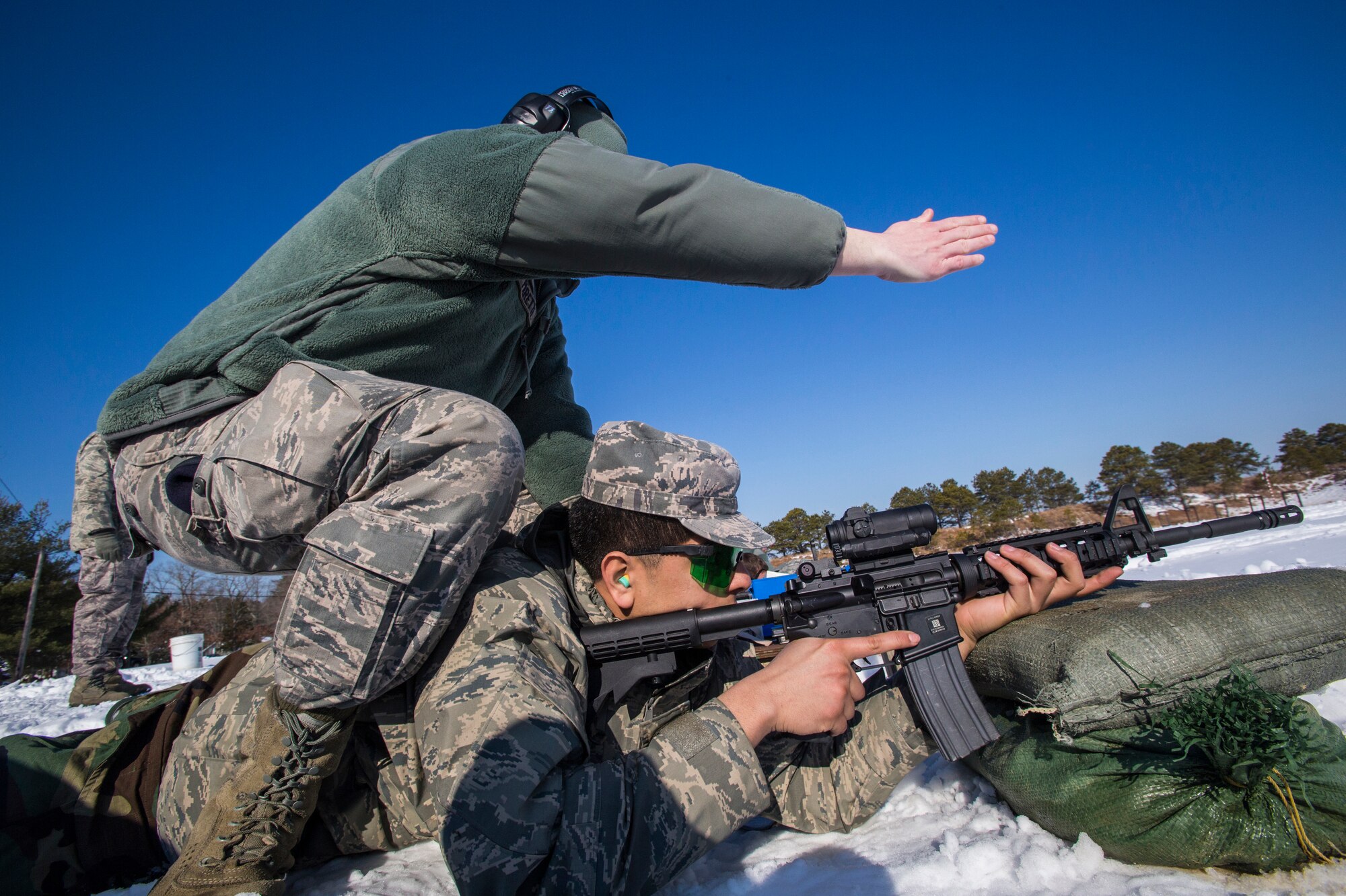 Senior Airman Joseph C. Paretti, standing, Combat Arms Training and Maintenance, gives guidance on the M4 Carbine to Senior Airman Anthony M. Zambrano, both with the 108th Wing, New Jersey Air National Guard, at Joint Base McGuire-Dix-Lakehurst, N.J., March 8, 2015. (U.S. Air National Guard photo by Master Sgt. Mark C. Olsen/Released)