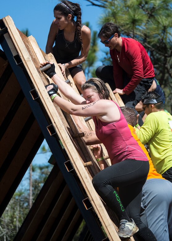 Senior Airman Heather O’Neil, 919th Special Operations Medical Squadron, climbs the Liberator during the Tough Mudder in Milton, Fla. March 7. Active duty and reserve service members came out to test their luck in the mud. Tough Mudder is a team-oriented 10-12 mile obstacle course designed to test physical strength and mental grit.  (U.S. Air Force photo/Tech. Sgt. Cheryl Foster)