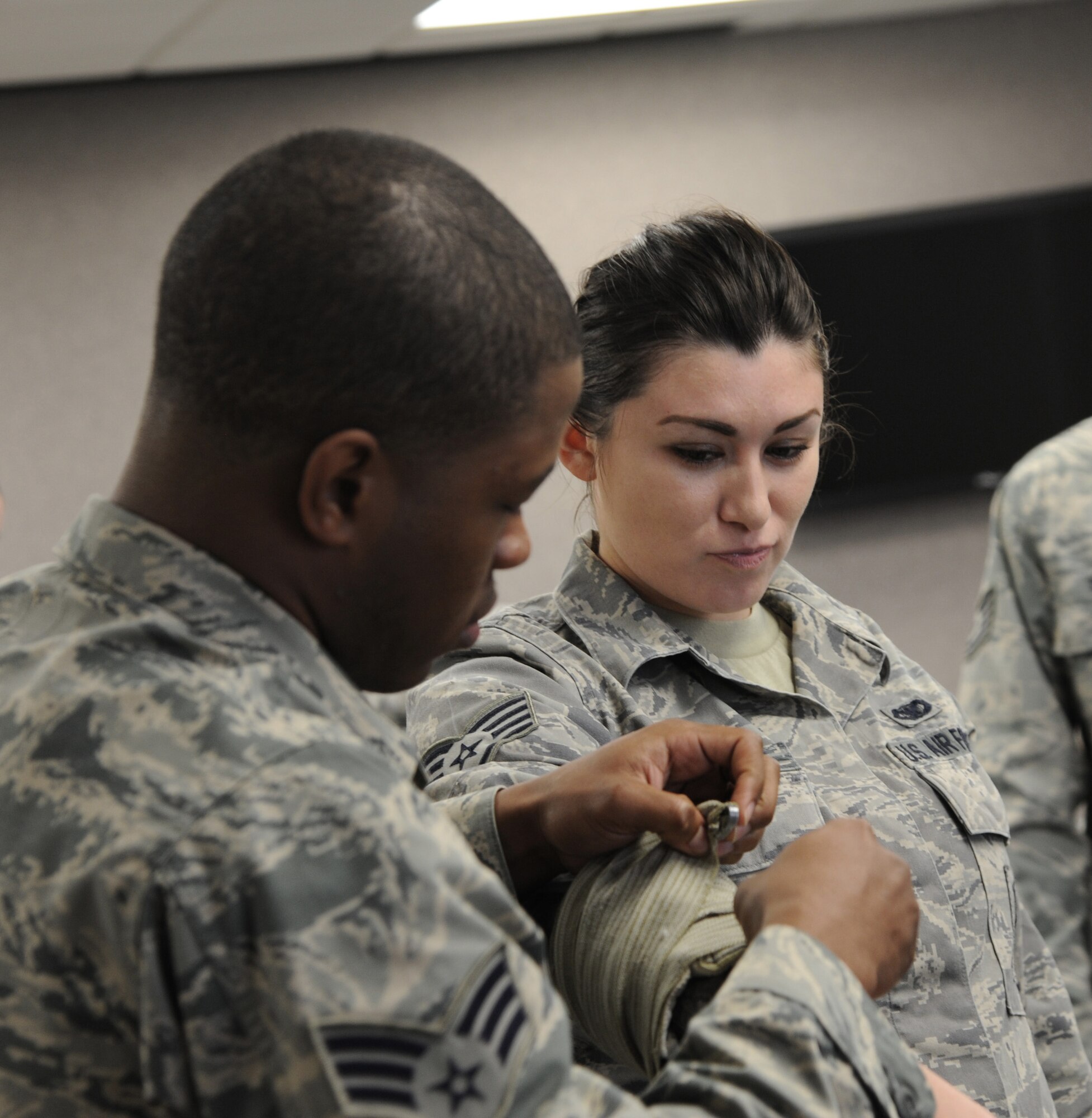 Members of the 927th Security Forces Squadron simulate placing a bandage on a wound during a Self-Aid and Buddy Care training at MacDill Air Force Base, Fla., March 8, 2015.  SABC trains Airmen on how to administer first aid, that may save their wingman’s life at home or in a deployed environment. (U.S. Air Force photo/Senior Airman Xavier Lockley)