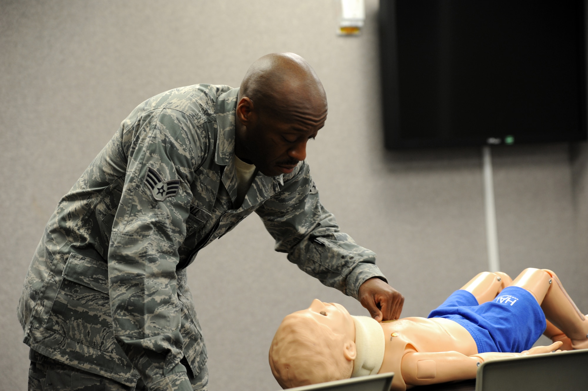 U.S. Air Force Senior Airman Reginald Randall, 927th Security Forces Squadron SABC instructor, checks a dummy’s chest during a Self-Aid and Buddy Care training at MacDill Air Force Base, Fla., March 8, 2015. Randall, was demonstrating the different ways of how to check for breathing in multiple locations of the body. (U.S. Air Force photo/Senior Airman Xavier Lockley)