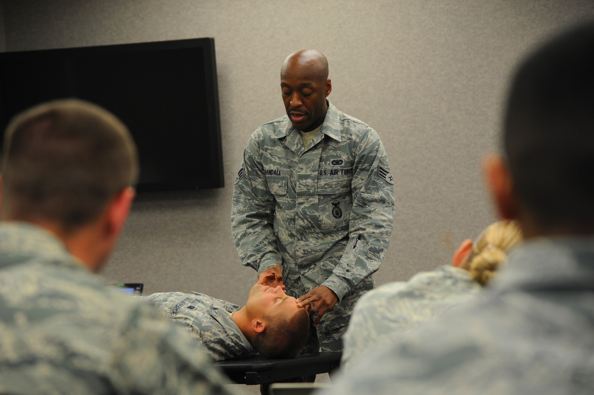 U.S. Air Force Senior Airman Reginald Randall, 927th Security Forces Squadron SABC instructor, demonstrates the head tilt chin lift maneuver during Self-Aid and Buddy Care training at MacDill Air Force Base, Fla., March 8, 2015. The members attended the training to fulfill a pre-deployment requirement. (U.S. Air Force photo/Senior Airman Xavier Lockley)
