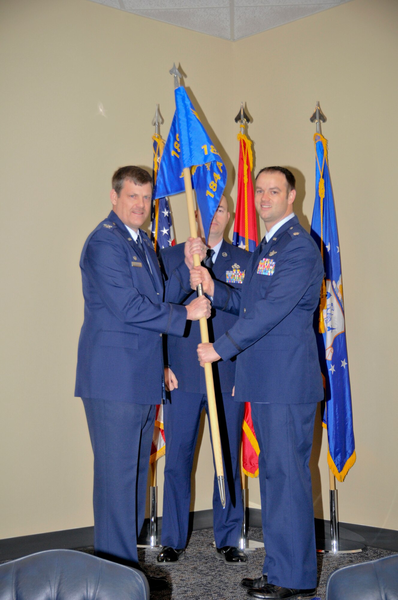 Col. Brian Burger, 188th Operations Group commander, passes the guidon to Lt. Col. Jeremiah Gentry, 184th Attack Squadron commander, signifying the assumption of command of the newly re-designated 184th ATKS March 8, 2015, during a ceremony held at Ebbing Air National Guard Base, Fort Smith, Ark. Gentry, a former A-10 Thunderbolt II "Warthog", MQ-9 Reaper and F-16 Falcon pilot, served on active duty for 11 years before transitioning to the Arkansas Air National Guard. (U.S. Air National Guard photo by Staff Sgt. John Suleski/released)