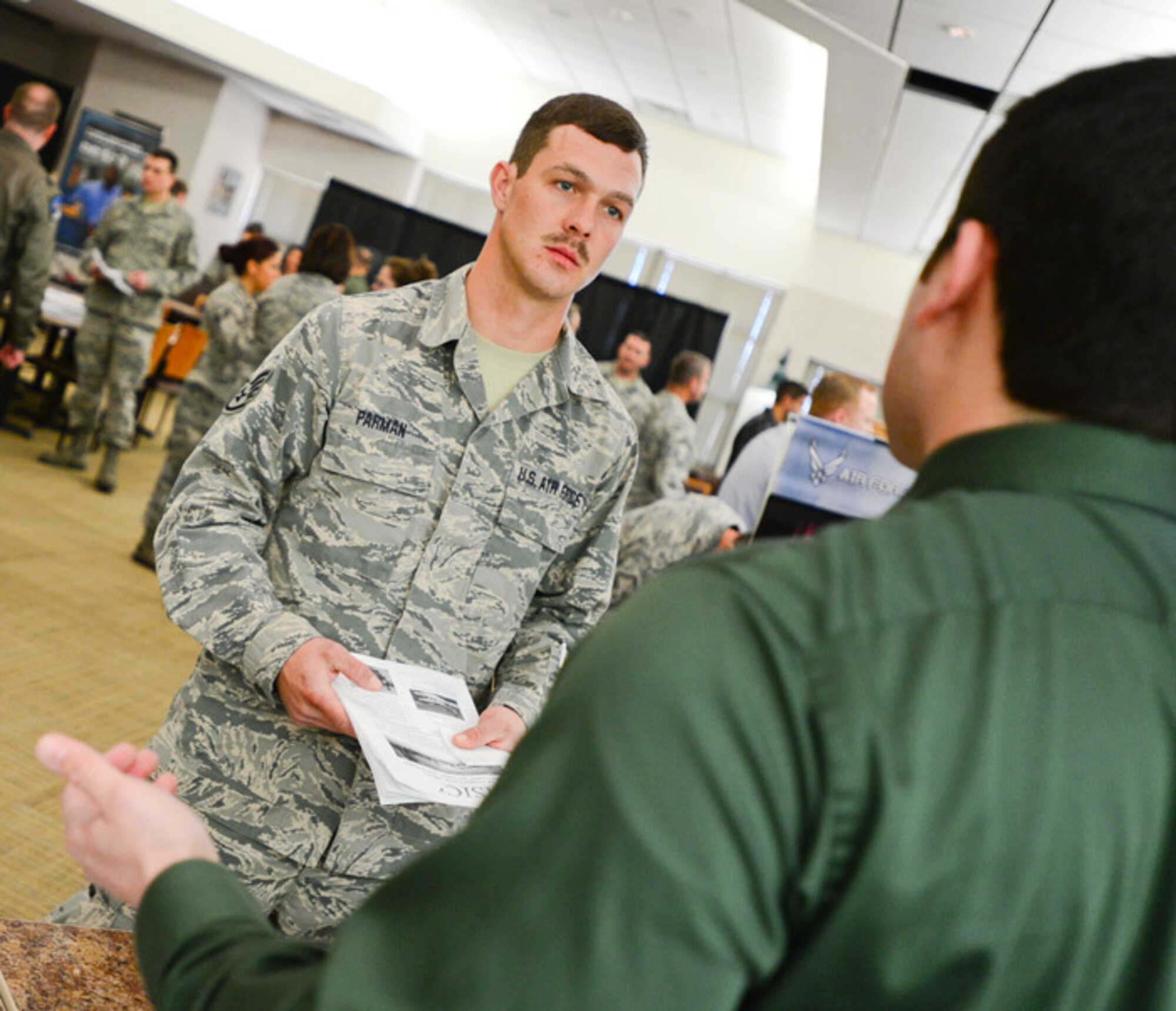 Staff Sgt. James Parman, crew chief of the 137th Aircraft Maintenance Squadron, listens to a representative from the career fair at Will Rogers Air National Guard Base, Oklahoma City, Oklahoma, Saturday, March 7, 2015. WRANGB hosted over 10 civilian and military employers for Airmen searching for full-time employment.  (U.S. Air Force photo by Airman 1st Class Tyler Woodward/released)