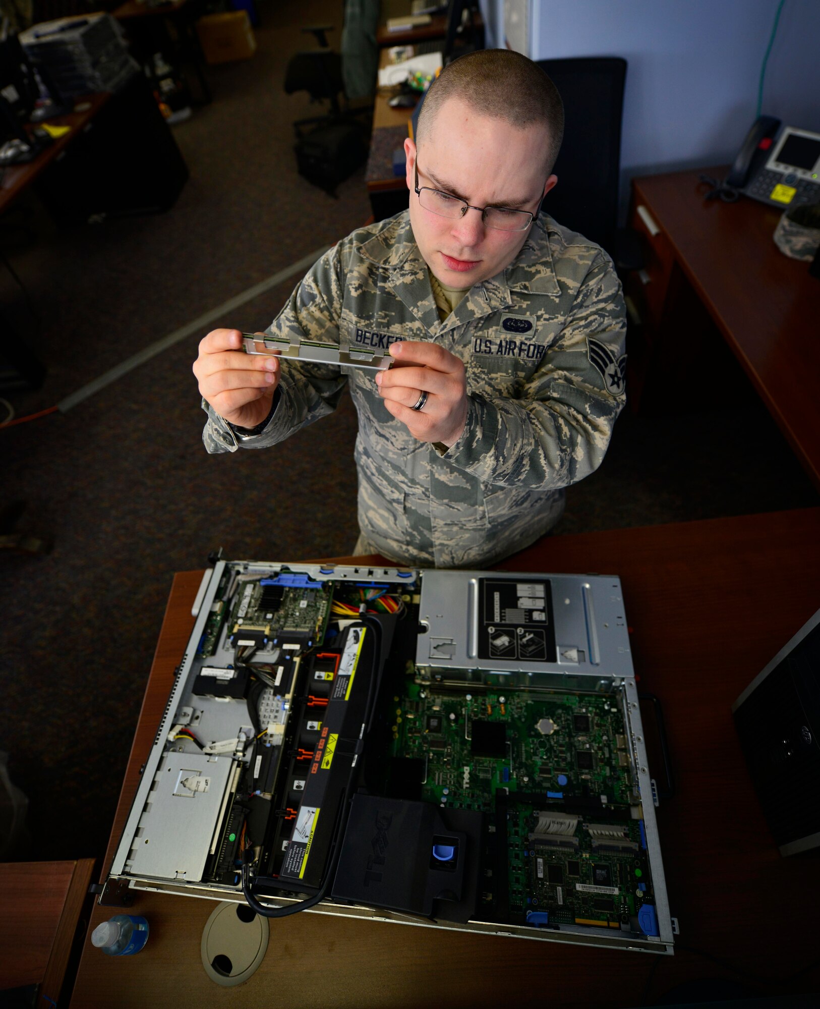 914th Airlift Wing Spotlight performer of the month for March 2015, Senior Airman Daniel J. Becker, Server Administrator, 914th Communication Squadron, examines parts of a computer, March 7, 2015, Niagara Falls Air Reserve Station, N.Y. (U.S. Air Force photo by Tech. Sgt. Stephanie Sawyer) 