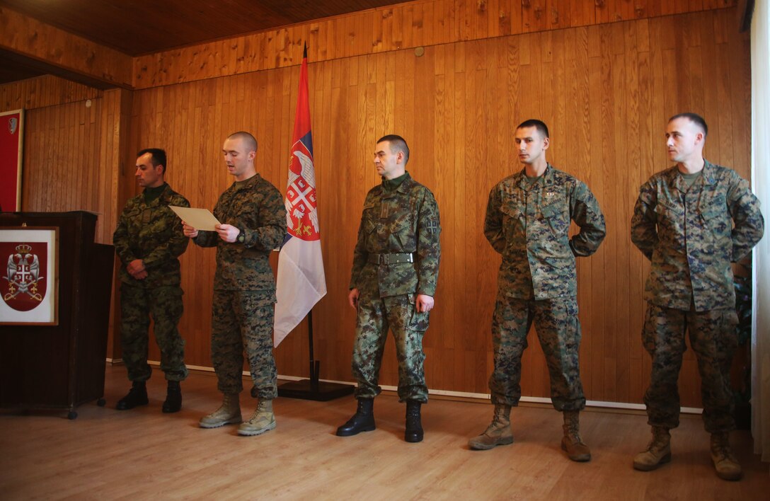 Commander of the Serbian Armed Force Training Center Pancevo, Maj. Sasha Petkovic, and U.S. Marines 2nd Lt. Caleb Clubb, Staff Sgt. Jonathan Sidhu and Staff Sgt. Dale Elbert stand before the group of Serbian Armed Forces services members upon completion of the NCO Workshop at the Serbian Armed Forces Training Center Pancevo, March 3 - 6, 2015. 25 Serbian Armed Forces service members worked with four U.S. Marines to share information about the noncommissioned officer rank. This engagement allowed for a greater understanding in Serbia’s effort toward NATO interoperability in the area of leader development. (U.S. Marine Corps photo by 1st Lt. Sarah E. Burns)