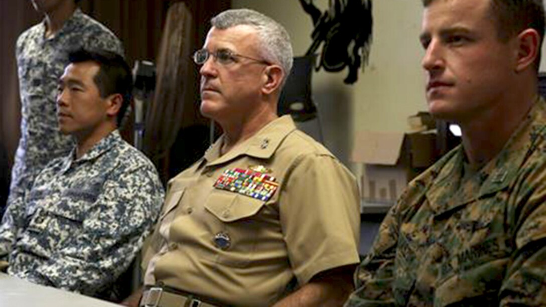 (From left to right:) Singaporean Lt. Col. Francis Goh, the commanding officer for the Underwater Demolition Group with Singapore’s Naval Dive Unit; Maj. Gen. James S. Hartsell, the mobilization assistant to the U.S. Pacific Command commander; and Capt. Richard Laszok, the company commander for Bravo Company, 3rd Reconnaissance Battalion, watch as members of the UDG give a presentation over Singapore’s dive tactics Feb. 27, 2015 in one of the School of Infantry-West classrooms in building 223 aboard Marine Corps Base Hawaii. The training was part of Exercise Sandfisher, an annual exercise that provides hands-on experience for Okinawa-based Marines specializing in combatant diving; small-boat operations; underwater navigation; high-altitude, high-opening parachuting and ground reconnaissance tactics.