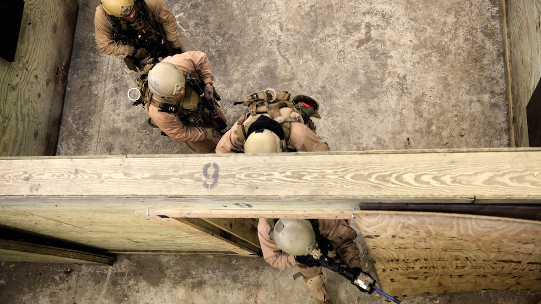 A fire team with 2nd Force Reconnaissance Detachment 6 moves into the hallway after clearing a room during a close-quarters tactics training event at Expeditionary Operations Training Group compound at Stone Bay aboard Marine Corps Base Camp Lejeune, N.C., March 6, 2015. Marines with 2nd FRD 6 clear and extract unknown targets in a building with narrow hallways and small rooms using tactics and safety standards they learned while at the reconnaissance and surveillance course conducted by EOTG. 