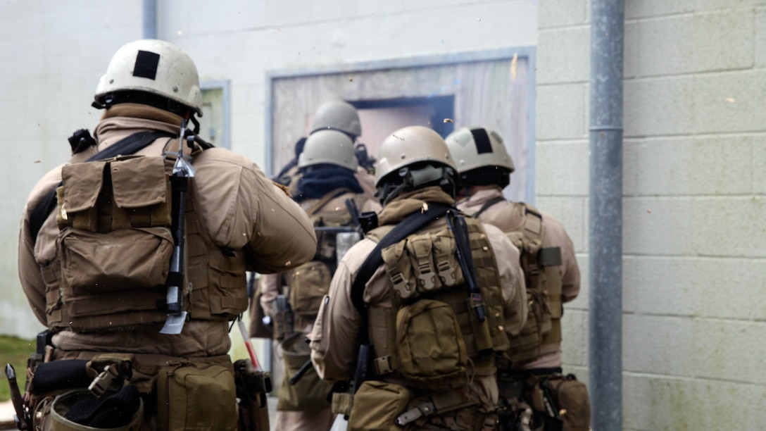 Marines with 2nd Force Reconnaissance Detachment 6 enters a building after breaching the door with a 3-strand detonation cord during a close-quarters tactics training event at Expeditionary Operations Training Group compound at Stone Bay aboard Marine Corps Base Camp Lejeune, N.C., March 6, 2015.  More than 35 Marines conducted the training during a pre-deployment training package provided by EOTG instructors.