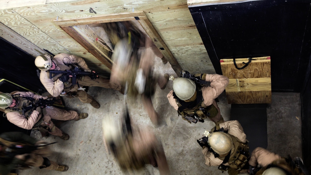 A fire team with 2nd Force Reconnaissance Detachment 6 enters a room after throwing in a flash bang during a close-quarters tactics training event at Expeditionary Operations Training Group compound at Stone Bay aboard Marine Corps Base Camp Lejeune, N.C., March 6, 2015. More than 35 Marines conducted the training during a pre-deployment training package provided by EOTG instructors.