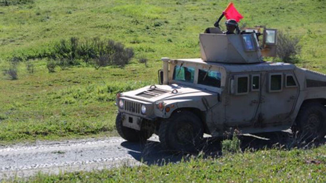 A Marine with 2nd Platoon, Truck Company, Headquarters Battalion, 1st Marine Division signals for pedestrians along the roadside to leave the area during a convoy operations training exercise aboard Marine Corps Base Camp Pendleton, California, March 3, 2015. The training exercise is designed to prepare the platoon’s junior Marines for convoy operations if they are in a deployed environment. 