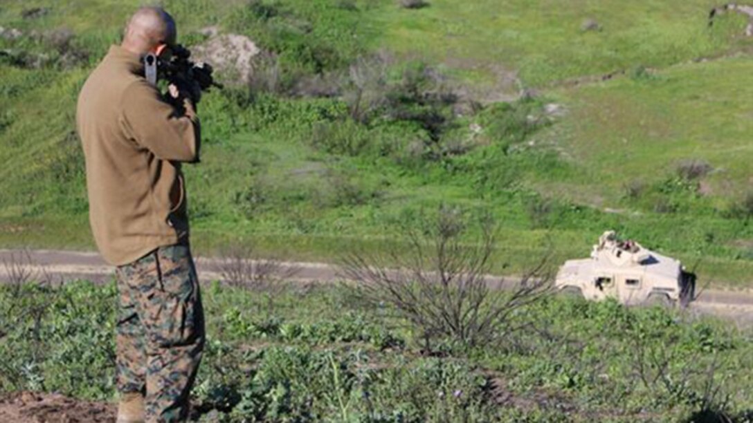 A Marine acting as an insurgent simulates firing rounds at a vehicle during a convoy operations training exercise aboard Marine Corps Base Camp Pendleton, California, March 3, 2015. The scenario was a way to test the junior Marines’ ability to respond to hostile situations. 