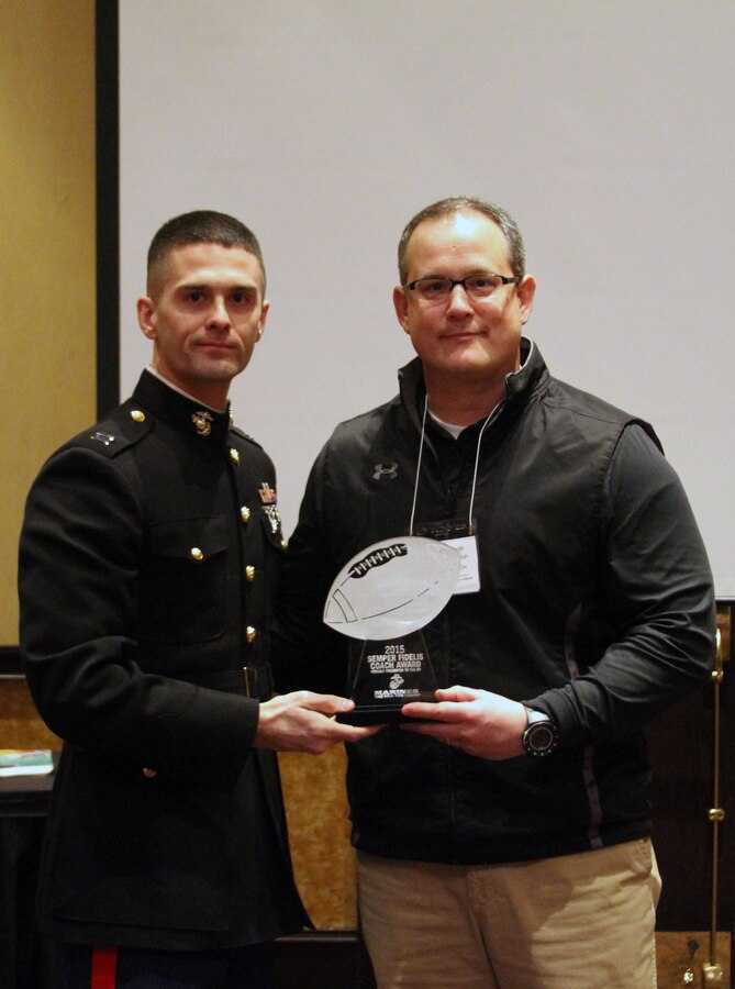 Rick Finotti, St. Edwards High School head football coach, receives the Semper Fi Coach Award from U.S. Marine Corps Capt. Brian Maurer, a Reserve Support Officer for Recruiting Station Cleveland and a Parma Heights, Ohio native, during the Cleveland Glazier Clinic Feb. 28, at the Bertram Inn and Conference Center in Aurora, Ohio. Finotti was selected for the distinction because of his devotion to leading young men, which embodies the values of honor, courage and commitment. (U.S.  Marine Corps photo by Sgt. T.M. Stewman)