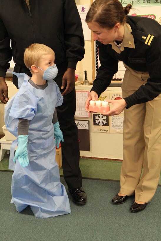 Navy Lt. Elise V. Hurrell, Naval Health Clinic Quantico, department head, Marine Corps Air Field Annex Dental Clinic, speaks with Ethan during a recent visit to Russell Elementary School to promote dental hygiene awareness as part of February’s National Children’s Dental Health Awareness Month. 
