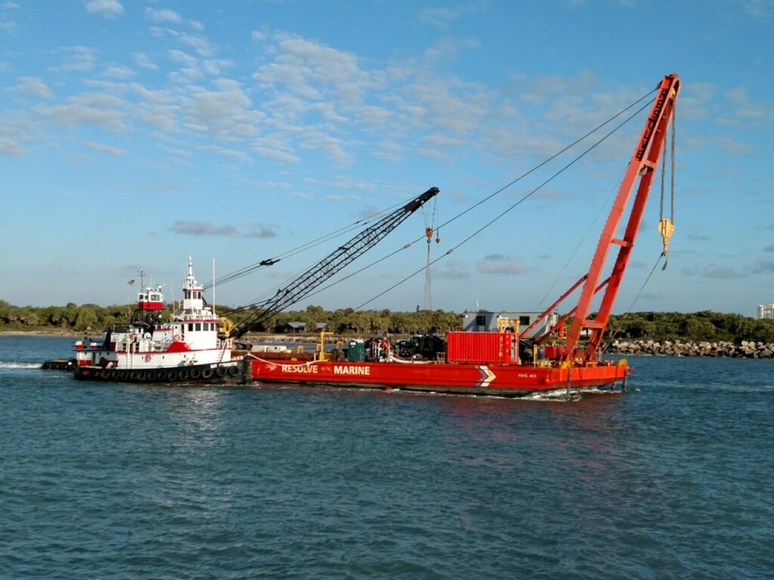 Tug boats assist the RMG-400 recovery vessel into place while wire cables are connected to four anchors.  The four-point mooring will help the recovery team maneuver at the wreck site. 