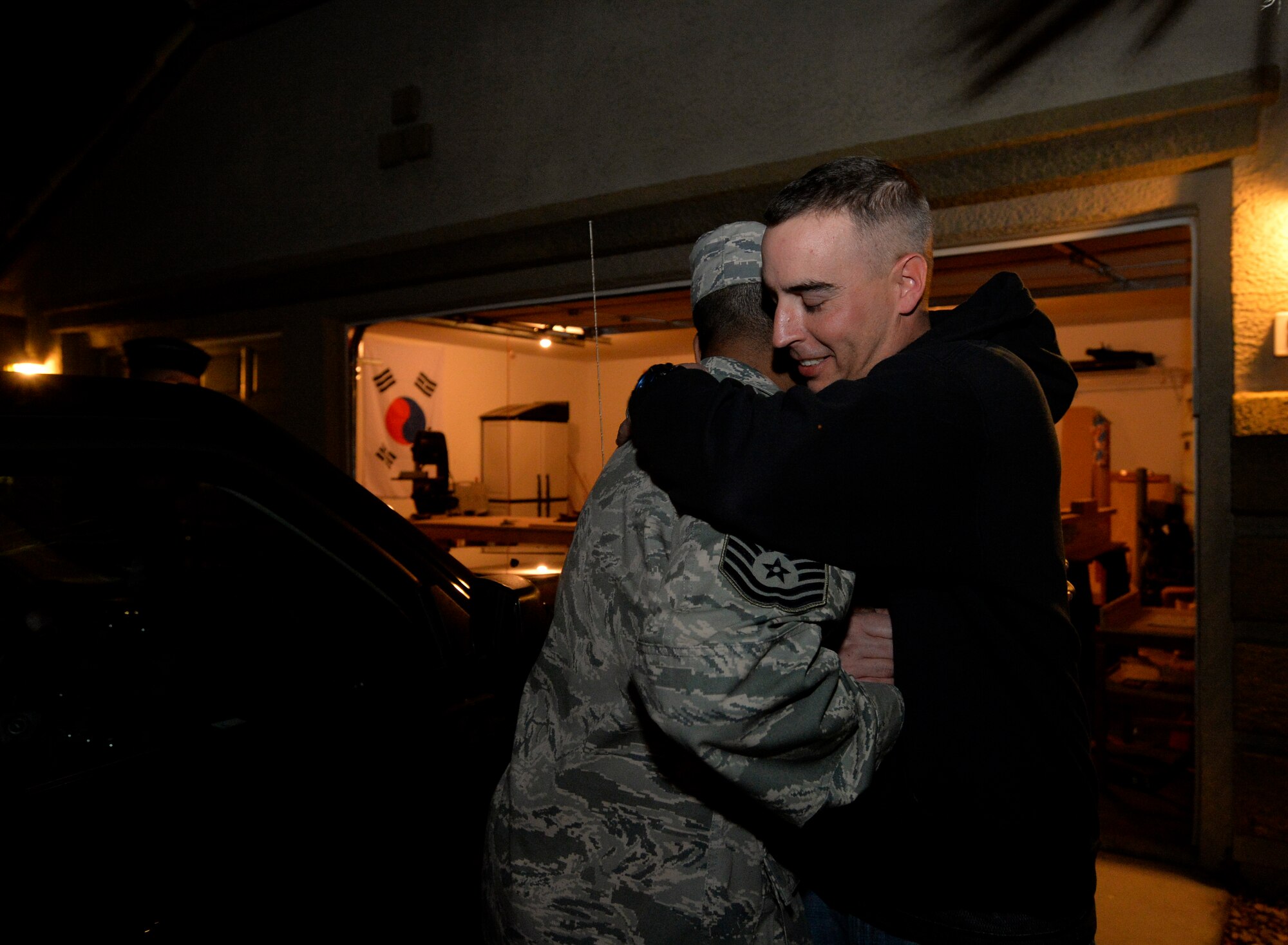 Chief Master Sgt. John Burks, 432nd Maintenance Group chief enlisted manager, left, hugs Master Sgt. Kenneth Eberman, 432nd Operations Support Squadron weather operations section chief, after the announcement of his selection to senior master sergeant, March 4, 2014. Leadership from the 432nd Wing/432nd Air Expeditionary Wing made sure that Creech Air Force Base’s newest senior master sergeants and their families were personally recognized for their achievements with an unexpected visit at their homes. (U.S. Air Force photo by Senior Airman Adarius Petty/Released)