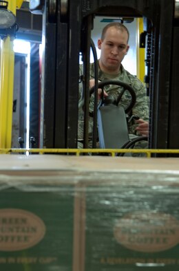 Staff Sgt. Joshua Yaworsky, 90th Logistics Readiness Squadron traffic management technician, picks up a palate of coffee supplies with a forklift March 3, 2015 in the 90th LRS cargo area on F.E. Warren Air Force Base, Wyo. The 40-foot trailer delivered 28 palates of coffee machines, coffee and mugs. (U.S. Air Force photo by Airman 1st Class Malcolm Mayfield)