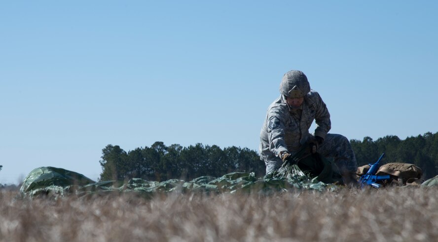 Master Sgt. David Brown tucks his parachute into a bag after completing a static line drop Feb. 19, 2015, at Tifton Air Field, Ga. The Airmen parachuted for 45 to 60 seconds before landing After exiting the aircraft. (U.S. Air Force photo by Staff Sgt. Eric Summers Jr./Released)