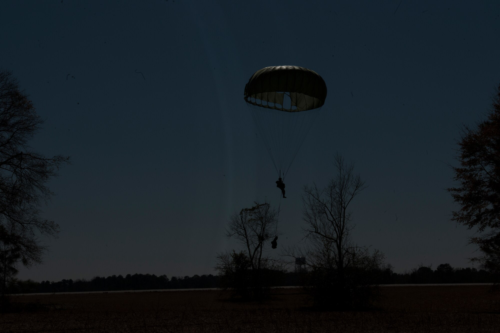 Master Sgt. David Brown, 820th Base Defense Group, guides his parachute away from trees into an open field Feb. 19, 2015, at Tifton Air Field, Ga. The aircraft made four passes by the drop zone to unload the 19 jumpers into the designated area. (U.S. Air Force photo by Staff Sgt. Eric Summers Jr./Released)