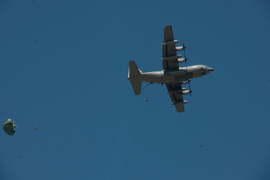 Airmen of the 820th Base Defense Group exit a C-130J Hercules during a static line drop Feb. 19, 2015, at Tifton Air Field, Ga. The Airmen practice for hours on using correct body form prevents tangling and helps parachutes open properly before actually jumping. (U.S. Air Force photo by Staff Sgt. Eric Summers Jr./Released)