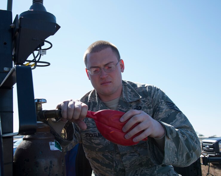 Staff Sgt. Corey Stickelman, 820th Base Defense Group, inflates a balloon used to measure winds and certain altitudes before a static line drop Feb. 19, 2015, at Tifton Air Field, Ga.  Members on the ground relay information to the jumpmaster on the ground to make sure conditions are safe for Airmen to jump. (U.S. Air Force photo by Staff Sgt. Eric Summers Jr./Released)