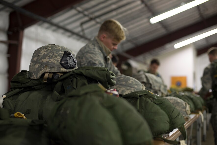 Senior Airman Christopher Stewart, 820th Base Defense Group, reviews his gear before securing it to his body during preparation for a static line drop Feb. 19, 2015, at Moody Air Force Base, Ga. Members of the 820th BDG are always on call to deploy worldwide and must maintain qualifications in several areas to including weapons and parachuting. (U.S. Air Force photo by Staff Sgt. Eric Summers Jr./Released)