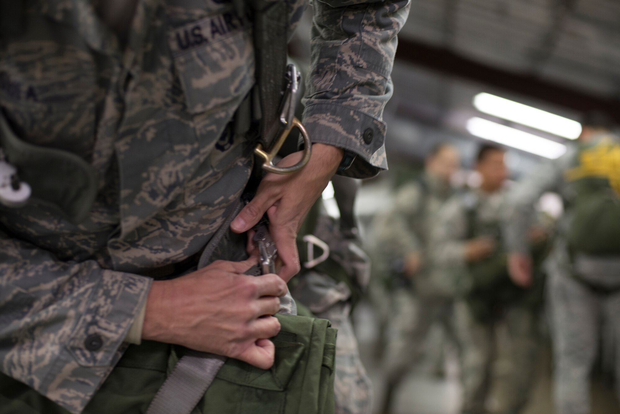 An Airman form the 820th Base Defense Group secures parachute gear to his body before participating in a static line drop Feb. 19, 2015, at Moody Air Force Base, Ga. The 820th provide fully-integrated, highly capable and responsive forces to protect Expeditionary Air Forces. (U.S. Air Force photo by Staff Sgt. Eric Summers Jr./Released)
