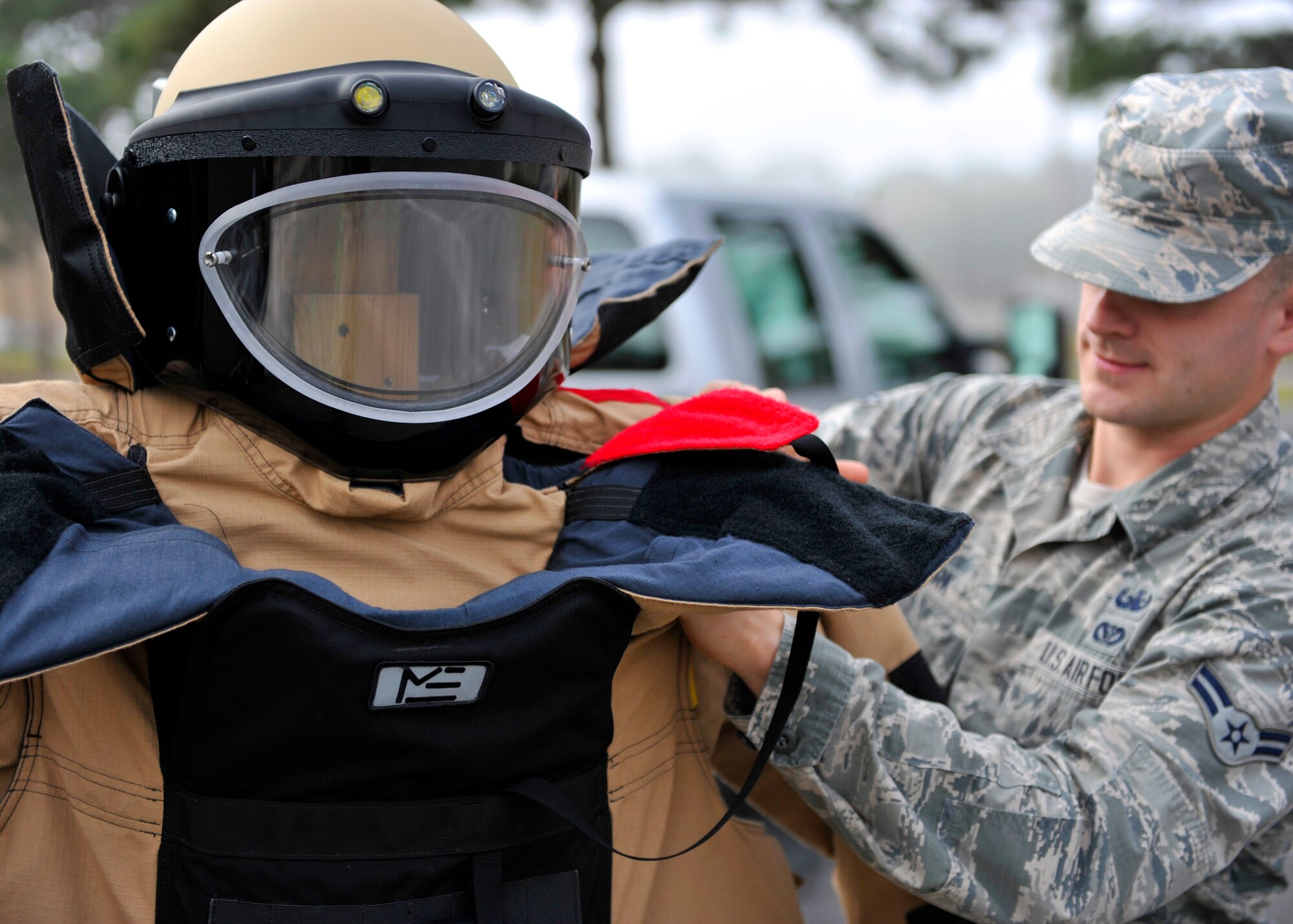 Airman 1st Class Anthony Clark, 325th Civil Engineer Squadron explosive ordnance disposal apprentice, starts disassembling an Explosive Ordnance Disposal 9 bomb suit March 5 at the EOD facility. Clark took apart the suit so the base commander could try on the 60-pound gear. (U.S. Air Force photo by Airman 1st Class Sergio A. Gamboa/Released)