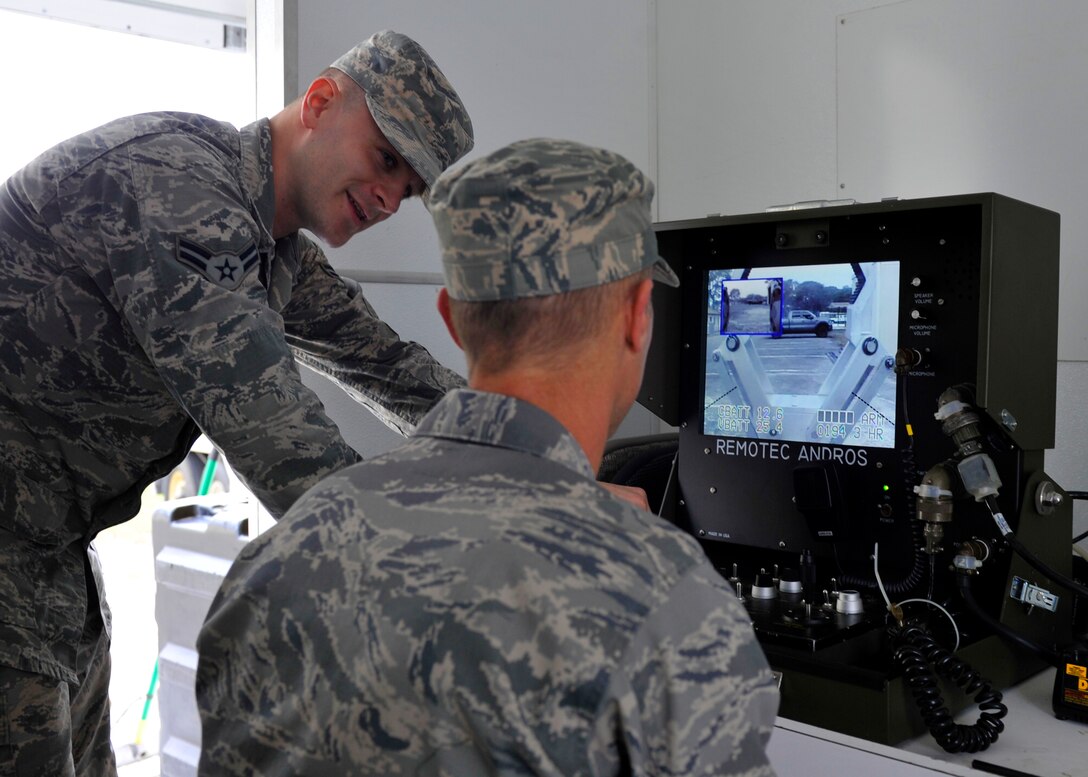 Airman 1st Class Anthony Clark, 325th Civil Engineer Squadron explosive ordnance disposal apprentice, shows Col. Derek C. France, 325th Fighter Wing commander, how to use the controls to direct their  robot March 5 at the EOD facility. Clark was this month’s Airman chosen to be shadowed as part of the Airman Shadow Program. (U.S. Air Force photo by Airman 1st Class Sergio A. Gamboa/Released)