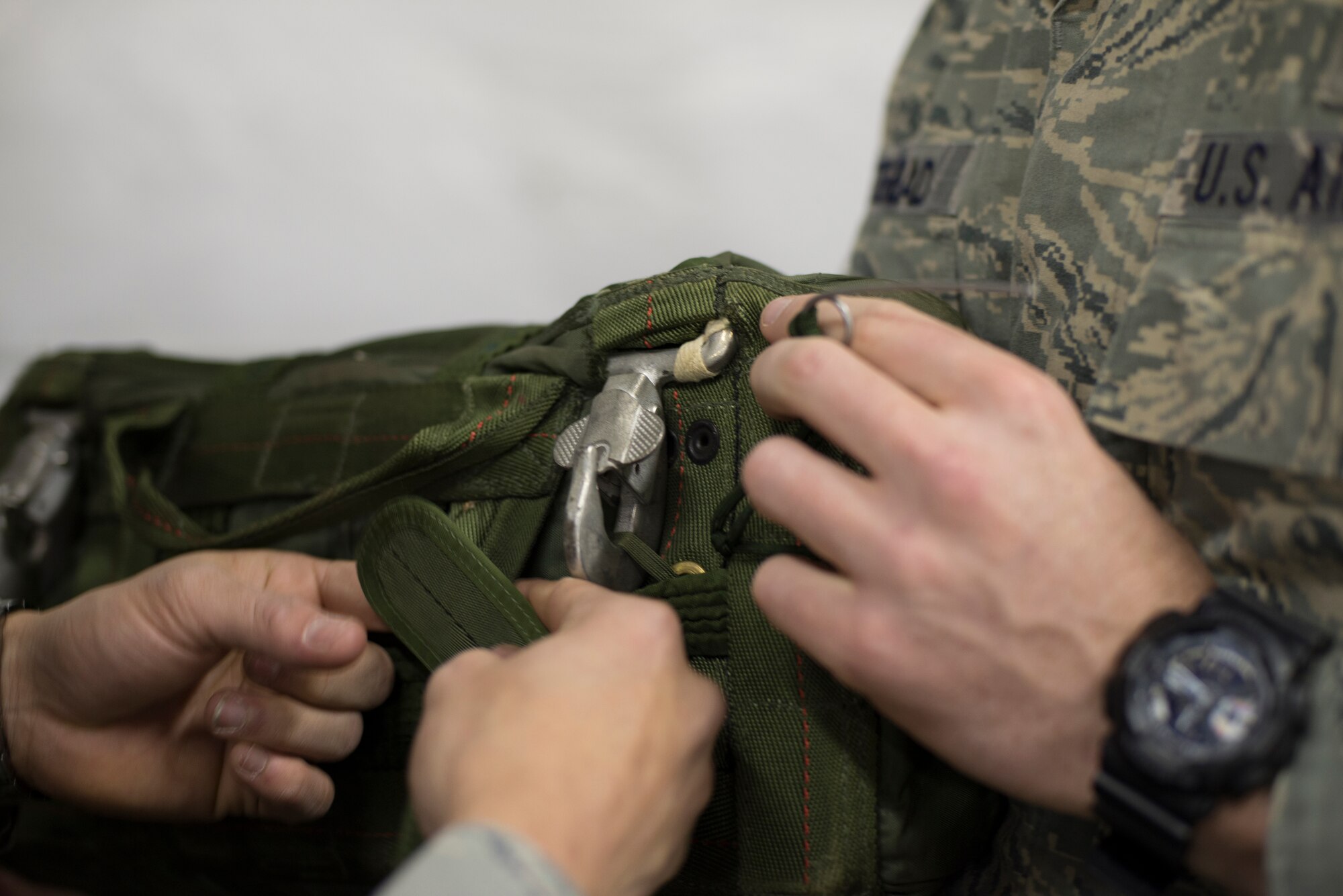 Airmen from the 820th Base Defense Group secure straps on parachute gear before a static line drop Feb. 19, 2015, at Moody Air Force Base, Ga. The 820th Combat Operations Squadron provides planning, training, equipping and preparation of the three security forces squadrons. (U.S. Air Force photo by Staff Sgt. Eric Summers Jr./Released)