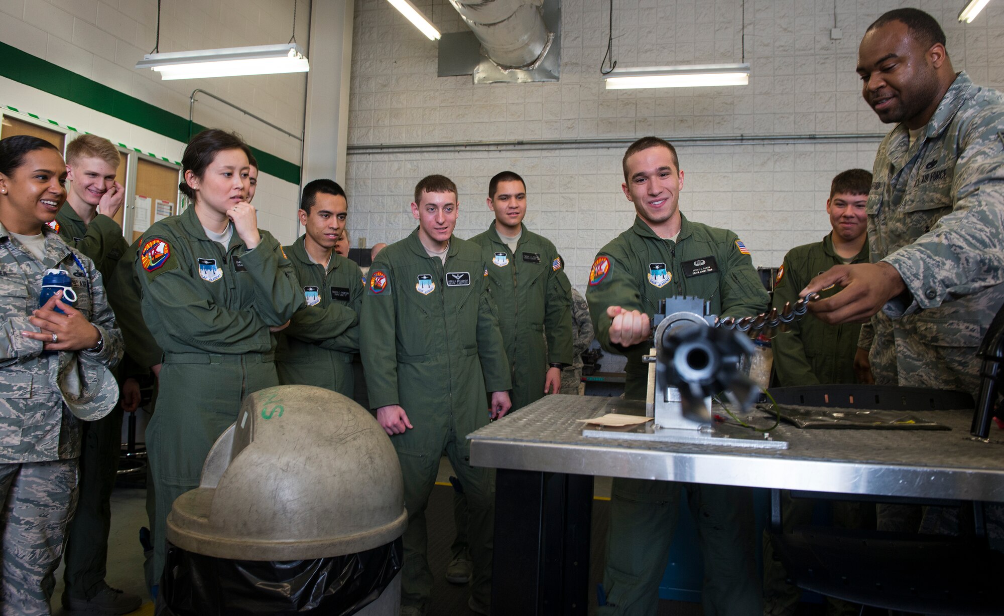 U.S. Air Force Staff Sgt. Mackel Stafford, right, 41st Helicopter Maintenance Unit load crew team chief, helps Cadet Henry Baron, Cadet Squadron 9 from the U.S. Air Force Academy, Colo., simulate firing a .50-caliber machine gun March 5, 2015, at Moody Air Force Base, Ga. The machine gun is one of two weapons system used by special missions aviators aboard HH-60G Pave Hawks. (U.S. Air Force photo by Airman 1st Class Ceaira Tinsley/Released)