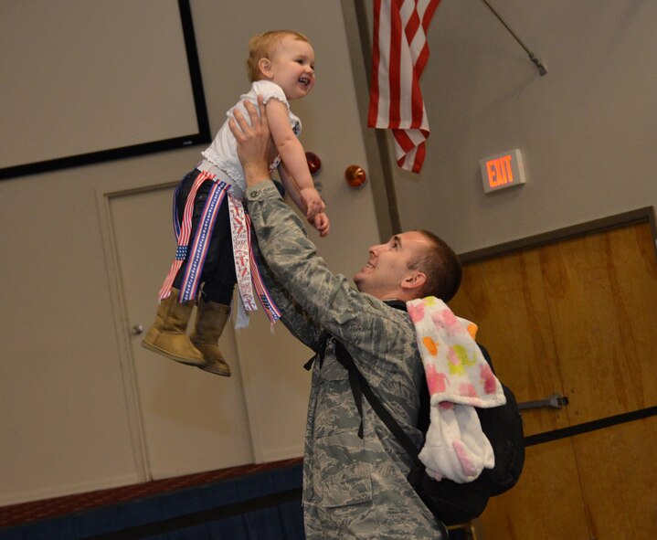 Senior Airman Dain Zielinski, 2nd Maintenance Squadron, plays with his daughter on Barksdale Air Force Base, La., March 9, 2015, after returning from a deployment. The Airmen returned from a deployment from Andersen Air Force Base, Guam, in support of the continuous bomber presence in the Pacific region. (U.S. Air Force photo/Senior Airman Benjamin Gonsier)