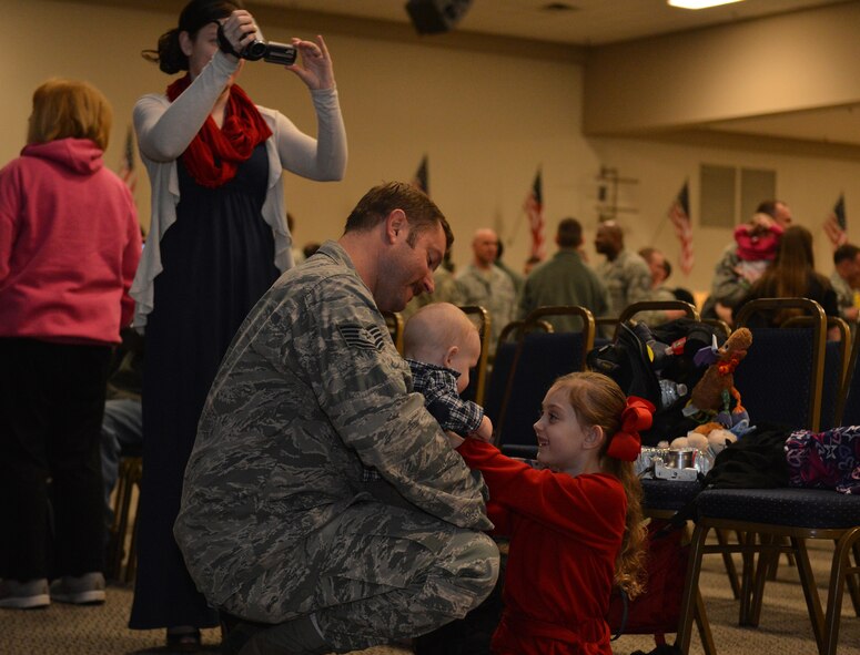 Tech. Sgt. Jason Lucius, 2nd Aircraft Maintenance Squadron, embraces his children on Barksdale Air Force Base, La., March 9, 2015. Lucius returned from Andersen Air Force Base, Guam, in support of Air Force Global Strike Command's deterrence mission in the Pacific region. (U.S. Air Force photo/Senior Airman Benjamin Gonsier)