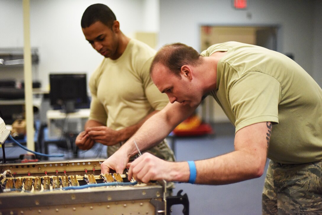 Staff Sgt. Nicholas Buck, , 341st Maintenance Operations Squadron electronics lab team chief (right), performs an inspection on a launch facility component as Senior Airman Christopher Scott, 341st MOS ELAB technician, assists during a routine maintenance session March 5. During maintenance, technicians must be grounded as they work on equipment to ensure static shock does not damage fragile equipment. (U.S. Air Force photo/Airman 1st Class Collin Schmidt)