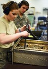Airman 1st Class Rachel Barnes, 341st Maintenenace Operations Squadron electronics lab technician (left), vacuums dust from a communications drawer as Staff Sgt. Christopher Setts, 341st MOS ELAB team chief, assists  during a routine maintenance session March 5. Before repairs can begin, all equipment must be thoroughly cleaned of dust and debris. (U.S. Air Force photo/Airman 1st Class Collin Schmidt)