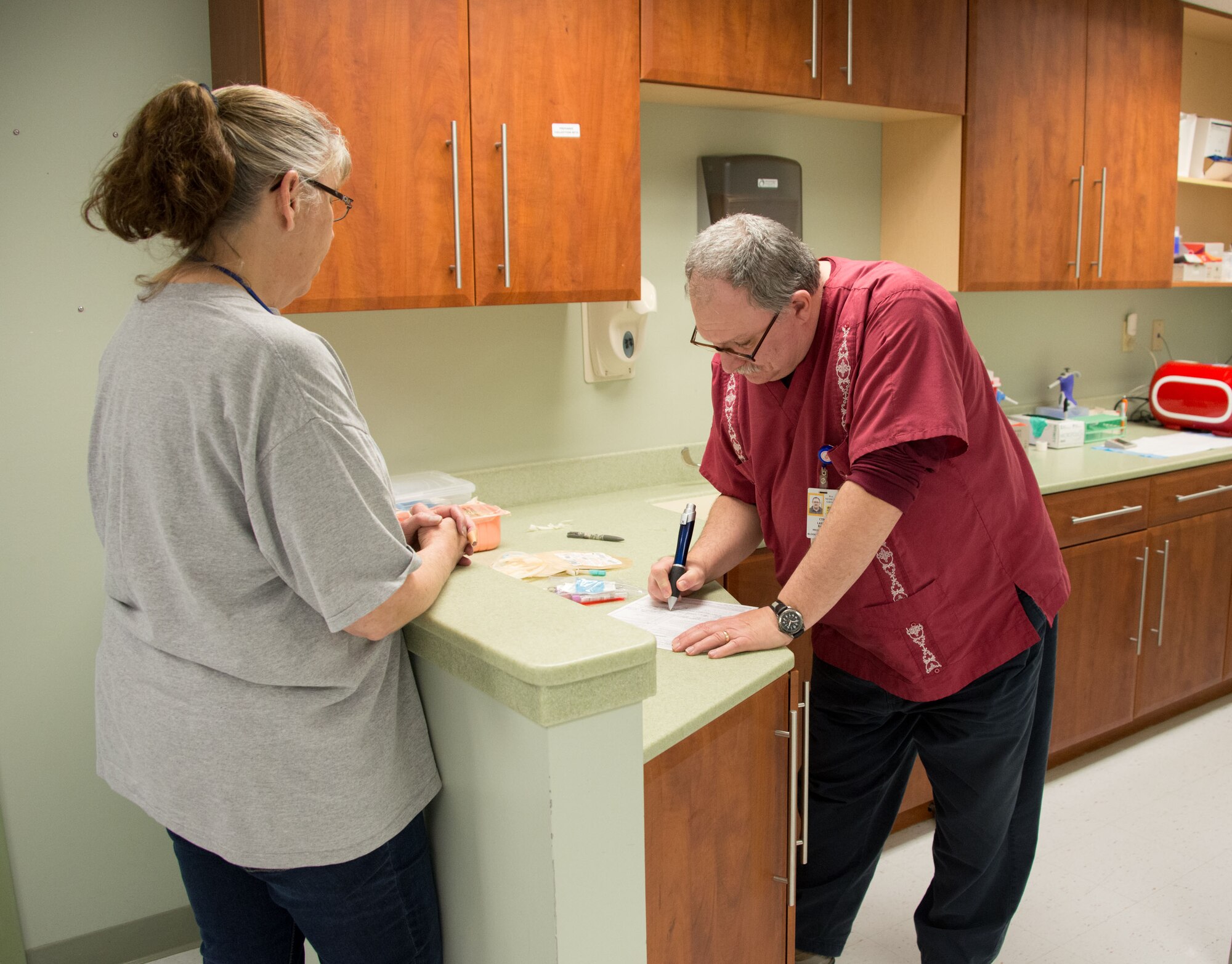 Larry Bank, 81st Diagnostic and Therapeutics Squadron medical technician, reviews paperwork for Susan Gardner, 334th Training Squadron commander support staff, prior to her donating blood March 6, 2015, at the blood donor center, Keesler Air Force Base, Miss. The center is located at the 81st Medical Group's Arnold Medical Annex. (U.S. Air Force photo by Marie Floyd)