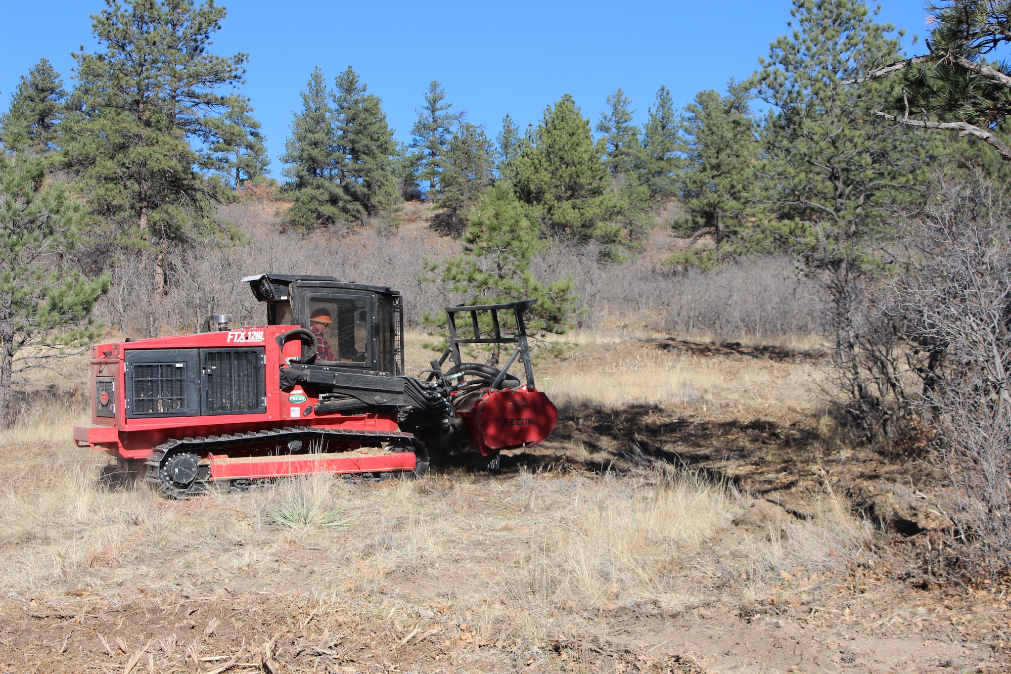 A worker clears brush at the U.S. Air Force Academy in Colorado, to limit the potential for catastrophic fires resulting from the build-up of brush and other fuels. The Air Force forestry program manages more than 570,000 acres; maintaining and creating healthy ecosystems to support military missions. (U.S. Air Force Photo/Kevin Elliott/Released)