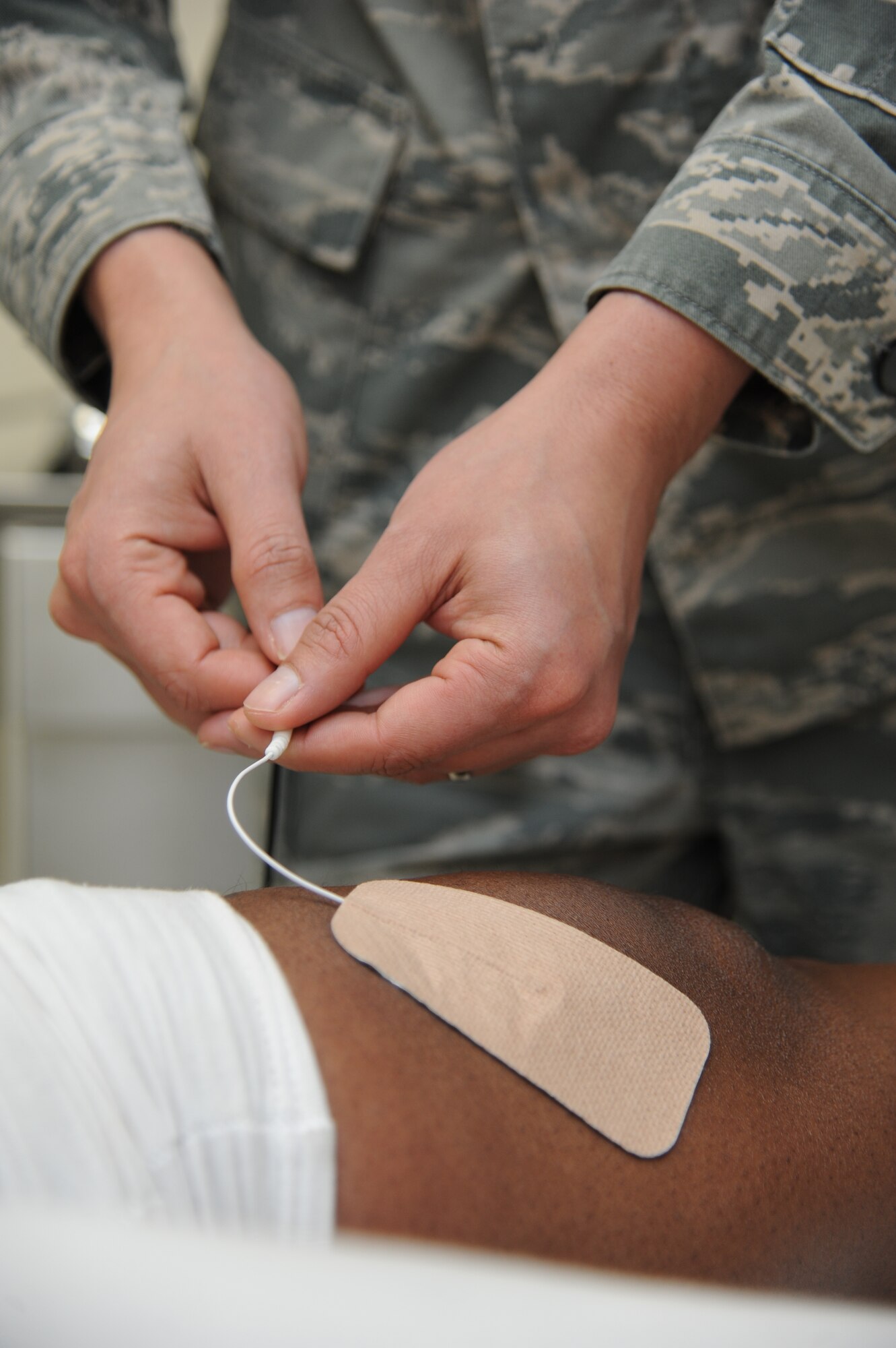Staff Sgt. Manuel Botero, 81st Surgical Operations Squadron physical medicine technician, applies electrical stimulation to a post-operation knee surgery patient March 4, 2015, at the Keesler Medical Center, Keesler Air Force Base, Miss.  Physical and occupational therapy is offered inside the medical clinic as well as at the Levitow Training Support Facility and Matero Hall to allow students direct access to them.  (U.S. Air Force photo by Kemberly Groue)