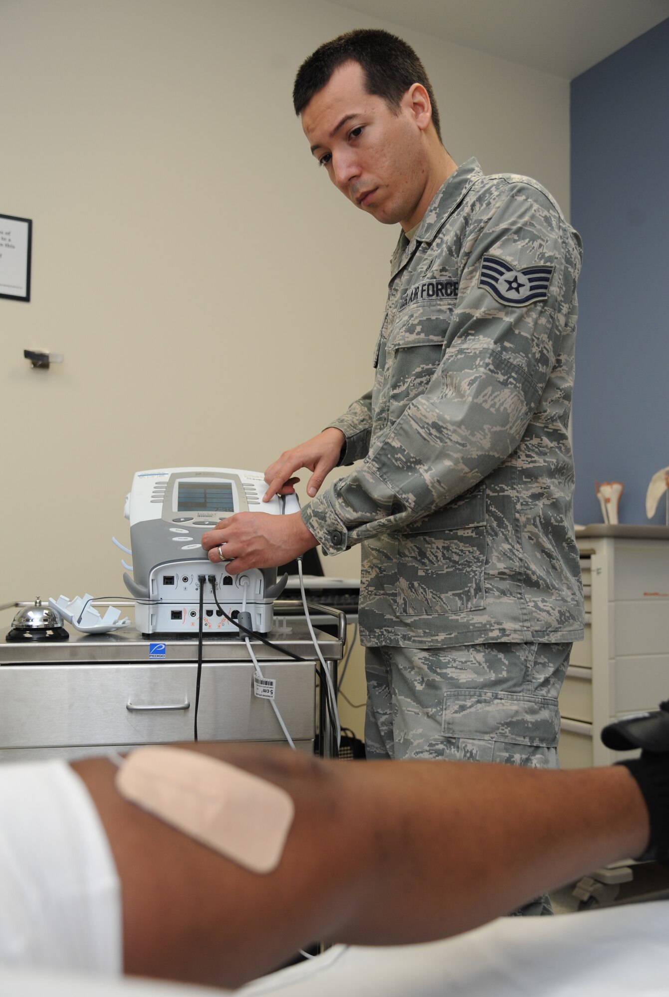 Staff Sgt. Manuel Botero, 81st Surgical Operations Squadron physical medicine technician, applies electrical stimulation to a post-operation knee surgery patient March 4, 2015, at the Keesler Medical Center, Keesler Air Force Base, Miss.  Physical and occupational therapy is offered inside the medical clinic as well as at the Levitow Training Support Facility and Matero Hall to allow students direct access to them.  (U.S. Air Force photo by Kemberly Groue)