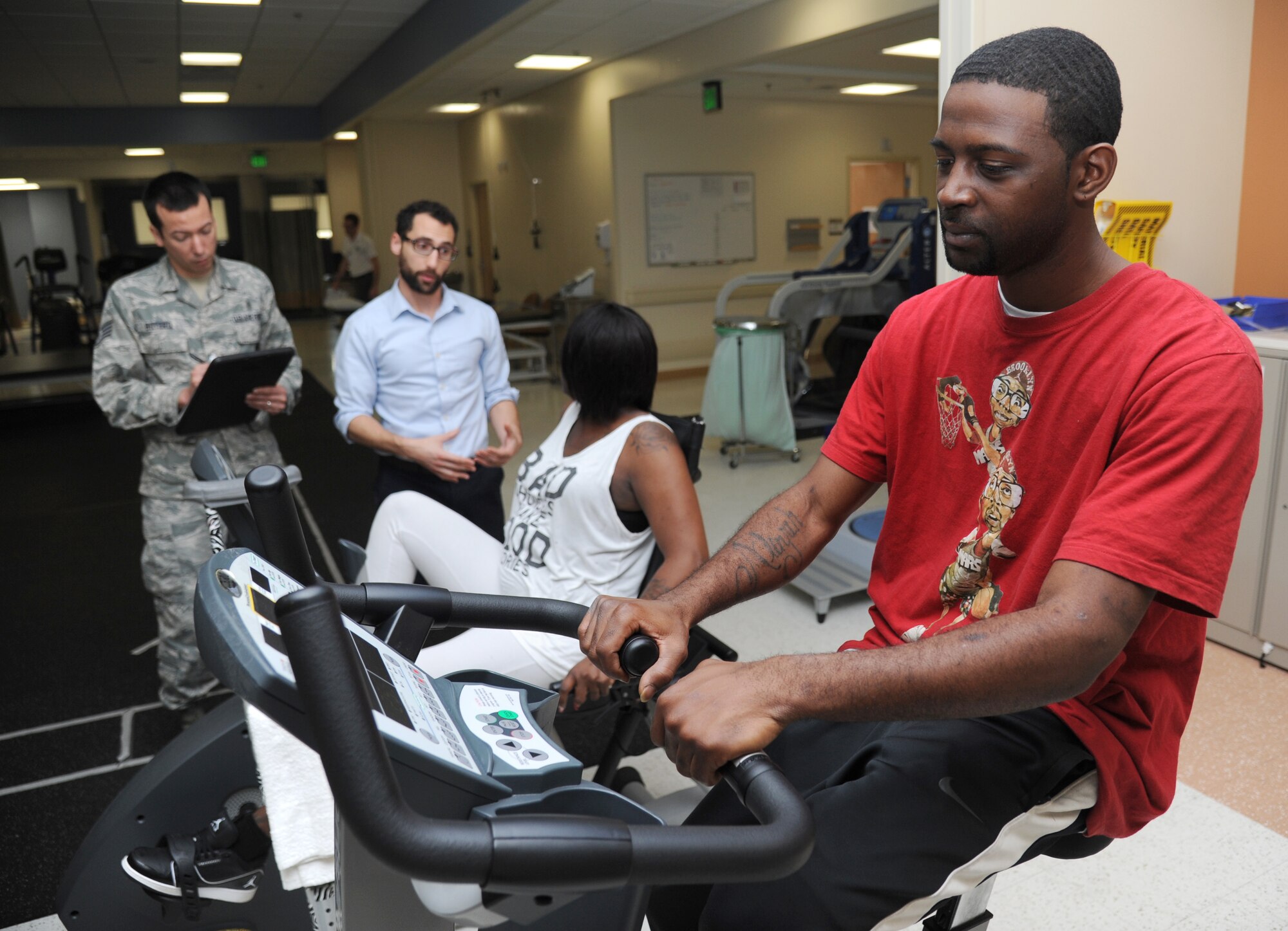 Javarius Lambert, spouse of Airman 1st Class Mia Lambert, 81st Inpatient Operation Squadron aerospace medical technician, uses a stationary bike to warm up for functional exercises March 4, 2015, at the Keesler Medical Center, Keesler Air Force Base, Miss. Physical and occupational therapy is offered inside the medical clinic as well as at the Levitow Training Support Facility and Matero Hall to allow students direct access to them.  (U.S. Air Force photo by Kemberly Groue)