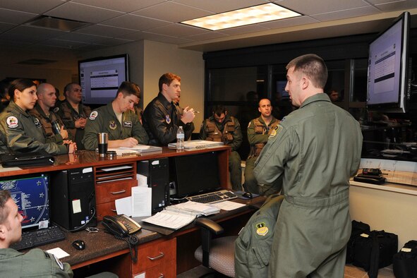 Capt. Sean Stavely, right, 20th Bomb Squadron assistant director of operations, briefs aircrew members at the step desk on Barksdale Air Force Base, La., March 3, 2015. During the step briefing, aircrew members are briefed on weather conditions, where their aircraft is parked and file paperwork. (U.S. Air Force photo/ Senior Airman Jannelle Dickey)
